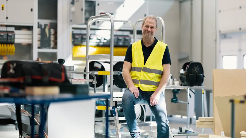Peter Borgström sitter på en stege i fabriken i Tingsryd
